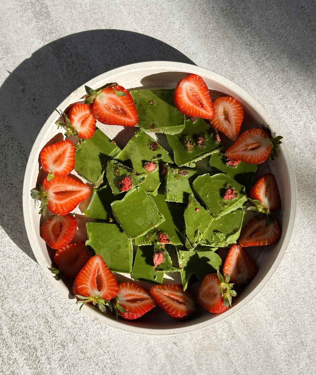 Handcrafted matcha white chocolate bark topped with freeze-dried strawberries and fresh halved strawberries. Made with premium Japanese My Match Co. powder for a vibrant, treat perfect for matcha lovers.